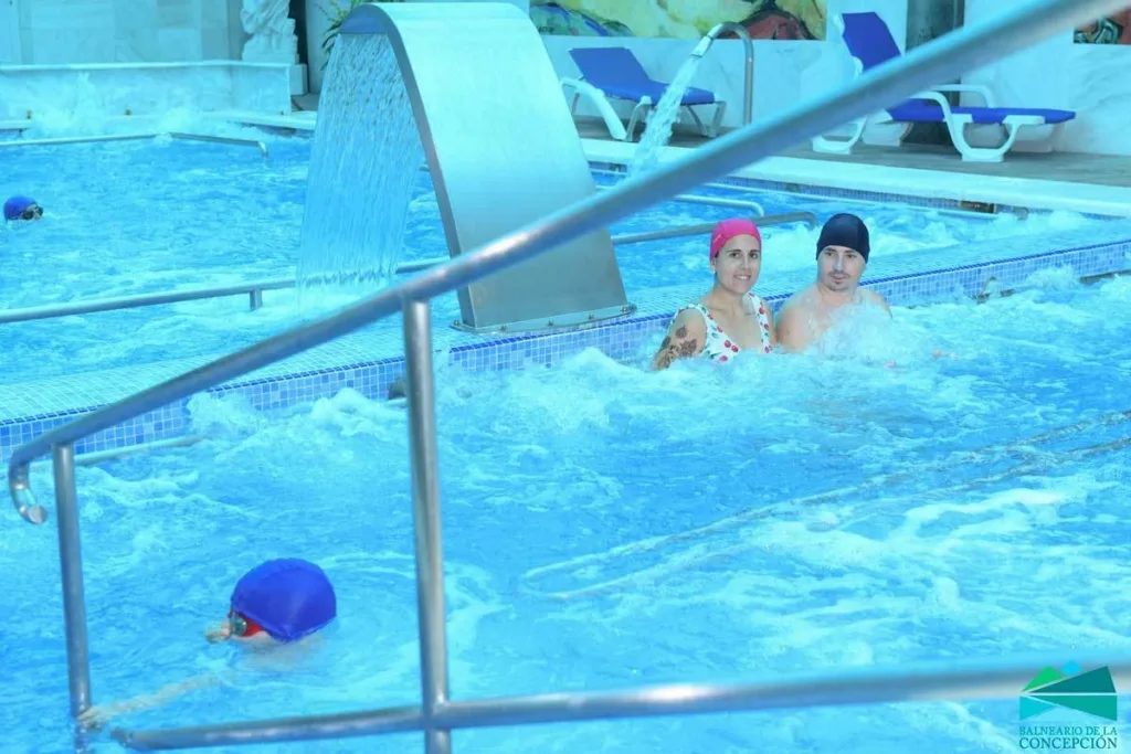 usuarios en piscina termal cubierta con chorros y cascadas de agua, zona de hidroterapia del balneario de la concepción en villatoya