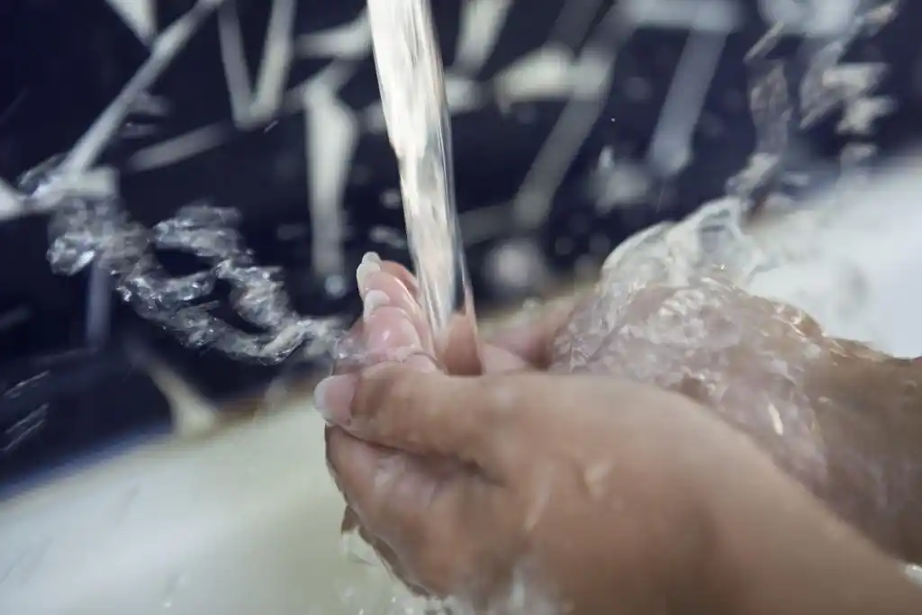manos bajo chorro de agua mineromedicinal en el balneario de la concepción, aguas termales de villatoya