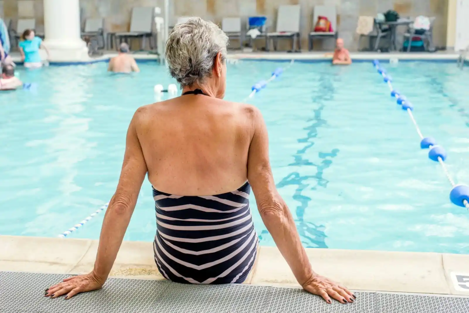 mujer mayor descansando en la piscina termal interior del balneario de la concepción, actividad de aguas termales para mayores