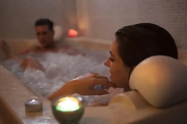 pareja relajándose en bañera de hidromasaje con velas, tratamiento de spa del balneario de la concepción en villatoya