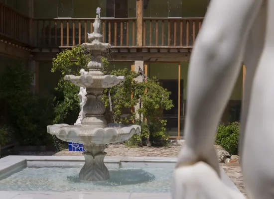 fuente de piedra en el patio central del balneario de la concepción, claustro ajardinado del hotel en villatoya