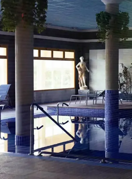 piscina termal interior con escaleras y estatua decorativa, zona de relax del balneario de la concepción en villatoya