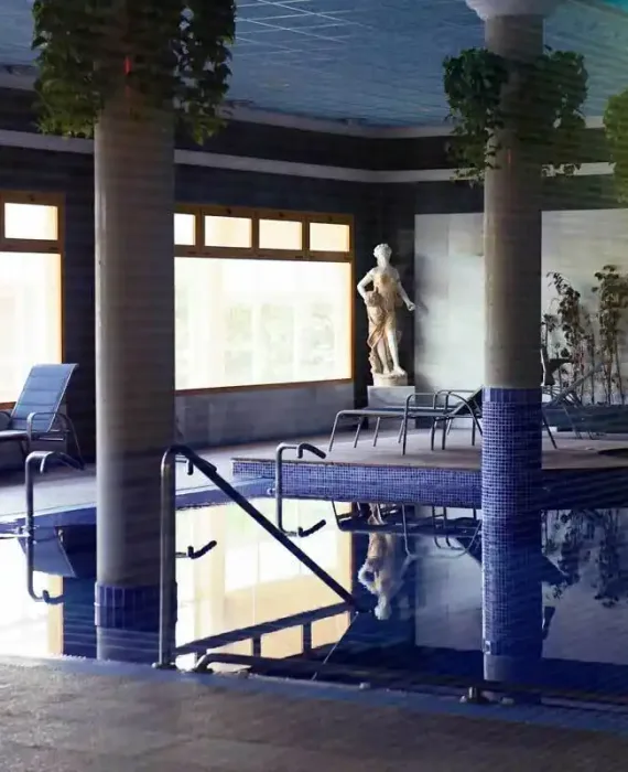 piscina termal interior con escaleras y estatua decorativa, zona de relax del balneario de la concepción en villatoya