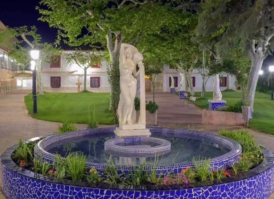 fuente iluminada con escultura femenina en los jardines del balneario de la concepción, espacio exterior del hotel en villatoya