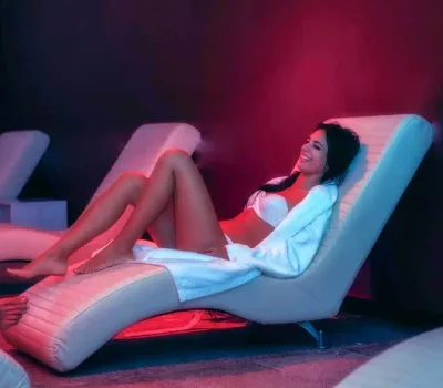 mujer relajándose en tumbona de calor con cromoterapia, zona wellness del balneario de la concepción en villatoya