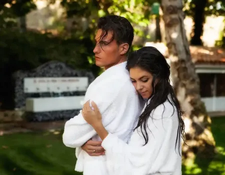 ChatGPT Plus pareja con albornoces blancos abrazándose en los jardines del balneario de la concepción, escapada romántica en villatoya