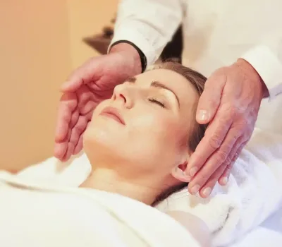 masaje craneofacial relajante en spa, manos del terapeuta sobre la cabeza de una mujer